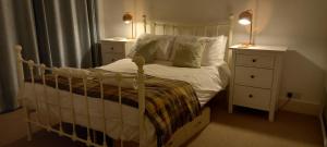 a bedroom with a bed with two night stands and two lamps at Sheila's Cottage in Lynton +13 photos