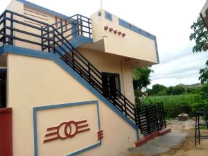 a house with a blue staircase on the side of it at Shiva Homestay Hampi in New Hampi