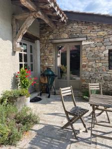 a patio with two chairs and a table in front of a building at Maison Revenu in Jalogny