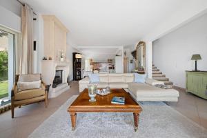 Villa Julia - Vue Mer - Jardin - Parking privé - في لا توربي: غرفة معيشة مع أريكة وطاولة قهوة