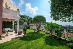 Villa Julia - Vue Mer - Jardin - Parking privé - في لا توربي: فناء خلفى لمنزل به ساحة خضراء