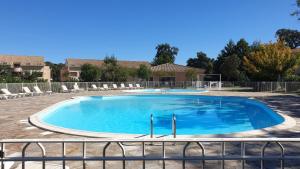 a large swimming pool with chairs and a fence at Casa di u sole in Santa-Maria-Poggio