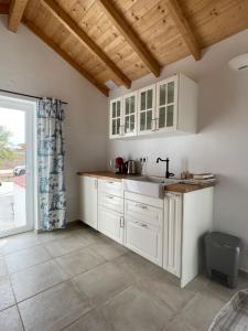 a kitchen with white cabinets and a sink at Quinta Madrugada Burgau in Luz