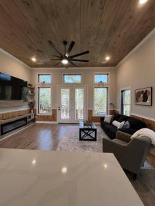 a living room with a ceiling fan and a couch at Cozy Cottage Retreat in Nature in Cedar Creek