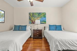 ウェストパームビーチにあるVibrant Oasis W Heated Pool 3 Units N Downtownの白い壁の客室で、ベッド2台、青い枕が備わります。 +62枚の写真