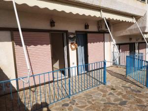 a row of pink doors on a building with a blue railing at BoLeTiS in Xiropigado