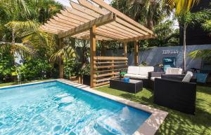 ウェストパームビーチにあるVibrant Oasis W Heated Pool 3 Units N Downtownの木製のパーゴラ付きの裏庭のスイミングプール