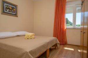 a bedroom with a bed with two teddy bears on it at Apartments Hari in Supetarska Draga