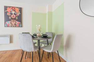 a dining room with a table and four chairs at Spacious 3-Bed Flat, Sleeps 7, Ideal for Families, Central Location, High-Speed Internet in Leicester