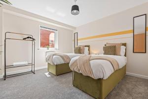 a bedroom with two beds and a mirror at Spacious 3-Bed Flat, Sleeps 7, Ideal for Families, Central Location, High-Speed Internet in Leicester