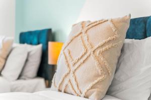 a beige pillow sitting on top of a bed at Stylish, 2-Bedroom Apartment for 4, Free PaModern 2-Bedroom Flat, Accommodates 4, Free Parking, Wi-Fi, Ideal for Families, City Centrerking, & Wi-Fi, Family-Friendly, City Centre in Liverpool