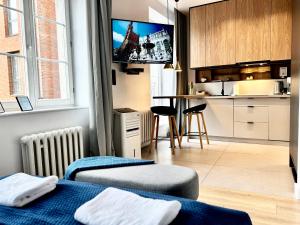 a room with two beds and a kitchen with a tv at Comfy Apartments - Old Town Center in Gdańsk