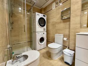 a bathroom with a toilet and a washing machine at Reinapart Patacona Beachfront Seaview in Valencia +93 photos
