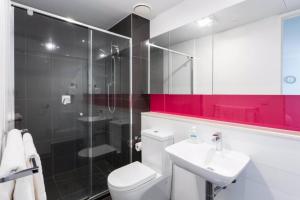 Un baño con inodoro, lavabo y ducha. en St Kilda Penthouse. Views. Spa., en Melbourne 35 fotos más