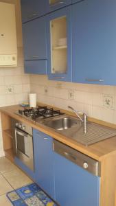 eine Küche mit blauen Schränken und einem Waschbecken in der Unterkunft Casa Rosa in Porto SantʼElpidio