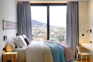 
a hotel room with a bed and a window at Coco-Mat Hotel Athens in Athens
