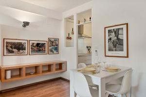 a white dining room with a white table and chairs at MareMiele, TerreMarine in Manarola