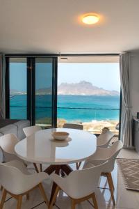 Una mesa y sillas blancas en una habitación con vista al océano. en Santa Ocean View, en Mindelo