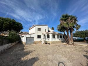 una casa blanca con una palmera delante en Villa Portalmar, en Benicarló