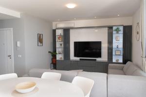 Una sala de estar con un sofá y un televisor en Santa Ocean View, en Mindelo