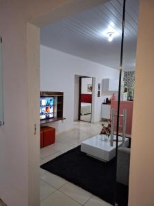 a living room with a table and a tv at Casa ampla com garagem a 3km da UFRB, Cruz das Almas in Cruz das Almas