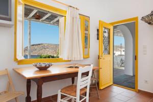 a dining room with a table and chairs and a window at Ceramic Lempesis House in Cherronisos