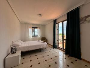 Un dormitorio con una cama y una ventana grande. en Villa Portalmar, en Benicarló