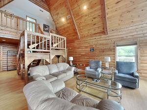 a living room with a couch and chairs and a staircase at Tranquil Cove in Sandy Ridge