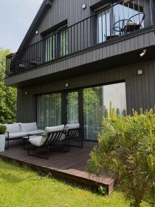 パランガにあるPajūrio Gintaro apartamentaiのデッキ(椅子付)、バルコニーが備わる家