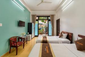 a hotel room with two beds and a chair at Smart Garden Homestay in Hoi An +48 photos