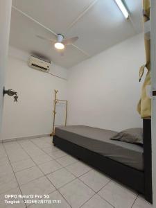 Kampong Sialang TengahにあるTANGKAK hOMESTAYのベッドと天井扇風機のある寝室 +3枚の写真