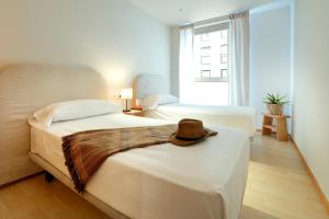 Una habitación de hotel con dos camas y un sombrero encima. en Vita Homes by Upper Luxury Housing, en Santiago de Compostela