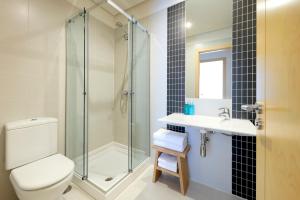 Un baño con ducha, inodoro y lavabo. en Vita Homes by Upper Luxury Housing, en Santiago de Compostela