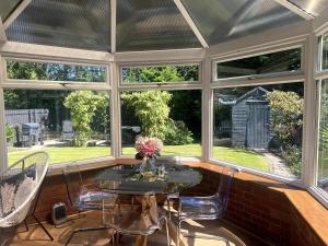 a screened in porch with a table and chairs at Home2Home Meadow Close in East Kilbride