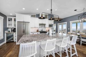 a kitchen with a marble counter top and white chairs at Nauti Beach Cottage in Lincoln City