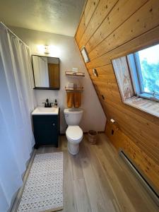 a bathroom with a toilet and a sink and a window at Peaceful A-Frame Cabin - Great Views with Hot Tub in Kremmling