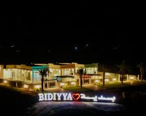 a building with a sign in front of it at night at Remal Resort Bidiyah in Badīyah