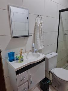 a bathroom with a sink and a mirror and a toilet at Casa ampla e confortável em Cruz das Almas in Cruz das Almas +29 photos