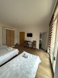 a bedroom with two beds and a desk with a television at Sobe Holiday Goražde in Goražde