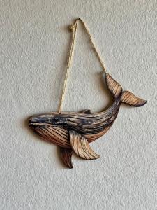 un adorno de ballena de madera colgado en una pared en Tropical Mar Profundo, en Santa Maria