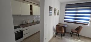 a kitchen with two chairs and a table and a window at Apartman Gora in Irig