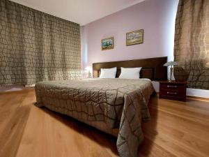 a bedroom with a large bed and a wooden floor at Family Art Hotel Gallery in Pleven