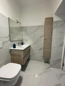 a bathroom with a toilet and a sink and a mirror at Casa lumiére in Bisceglie