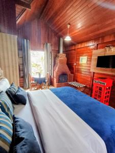 a bedroom with a large bed and a fireplace at Pousada Mon Desir in Penedo