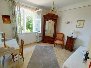 a bedroom with a bed and a table and a mirror at L'Enclos du Château in Courthézon