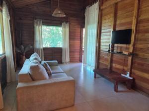 a living room with a couch and a tv at Cabana das Mandalas in Itacaré