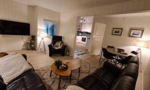 a living room with a couch and a table at Sentrumsnær sokkelleilighet in Bardu