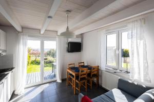 a living room with a table and a kitchen with windows at NORDA in Kuźnica