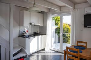 a kitchen with white cabinets and a table and a window at NORDA in Kuźnica