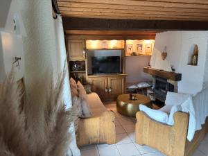 a living room with a couch and a television at Chalet de Manigod in Manigod
